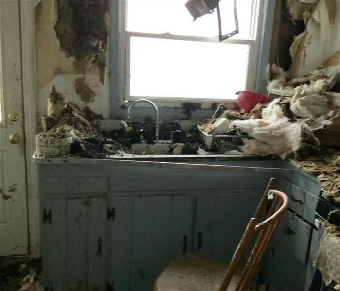 Kitchen sink and cabinets with fire damage and debris