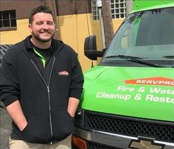 employee, black jacket front of truck