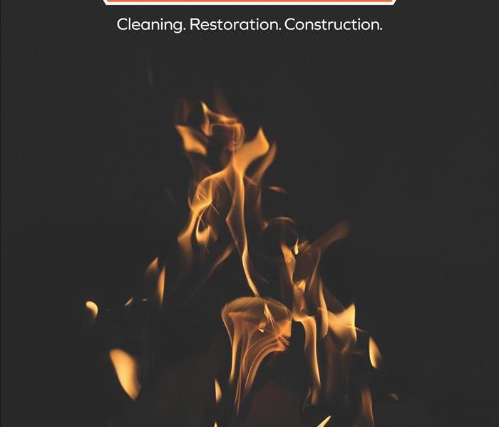 Black backdrop with a fire displaying servpro logo